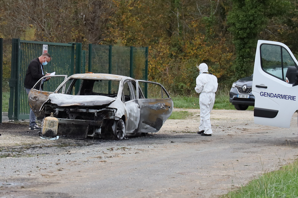 Investigators inspect the burned car after a motorist deliberately rammed pedestrians and cyclists across two neighbouring towns on the Ile d'Oleron, a quiet French island popular with tourists off the Atlantic coast, Wednesday, Nov. 5, 2025. (AP Photo/Yohan Bonnet)