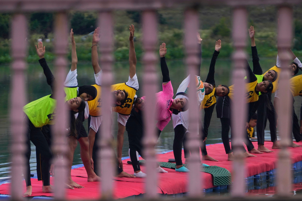 Participants perform yoga during an International Yoga Day event at Pokhrabal Lake in Srinagar, Indian controlled Kashmir, Sunday, June 21, 2026. (AP Photo/Mukhtar Khan)