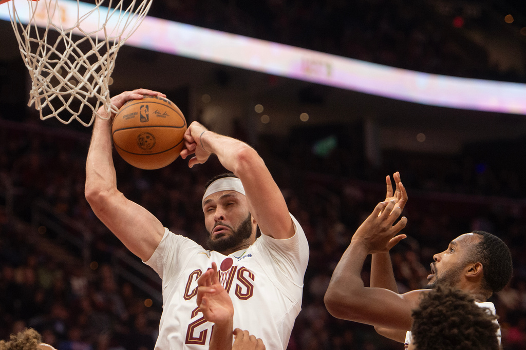 Cleveland Cavaliers' Larry Nance Jr., center, grabs a rebound as Evan Mobley, (left) looks on during the first half of an NBA basketball game against the Atlanta Hawks in Cleveland, Sunday, Nov. 2, 2025. (AP Photo/Phil Long)