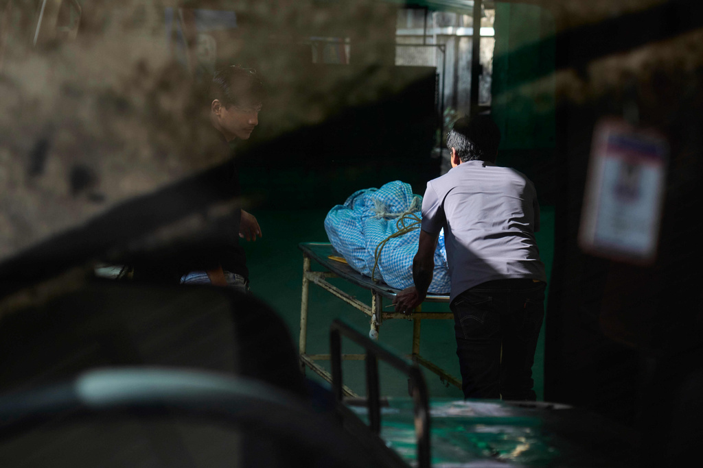 Hospital staff unload the body of a climber killed in an avalanche on Mount Yalung Ri at the morgue of Tribhuvan University Teaching Hospital in Kathmandu, Nepal, Wednesday, Nov. 5, 2025. (AP Photo/Niranjan Shrestha)