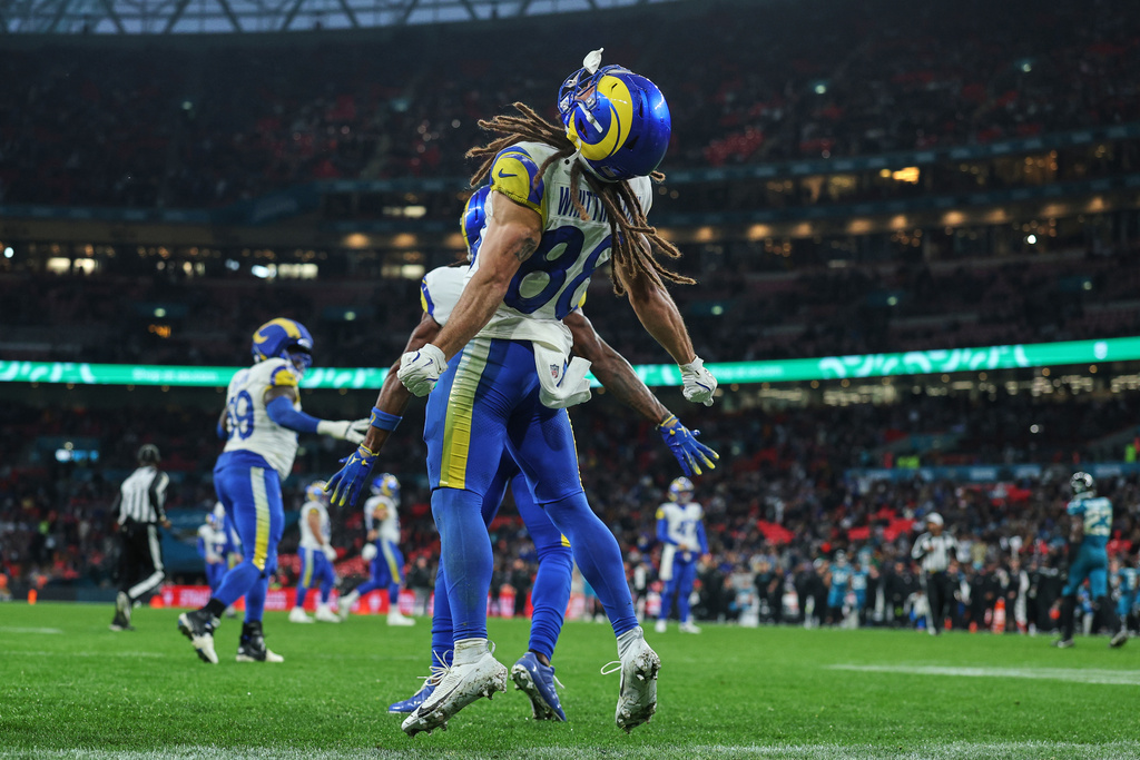 Los Angeles Rams wide receiver Jordan Whittington (88) celebrates after teammate wide receiver Davante Adams (17) scored a touchdown during the second half of an NFL football game between the Los Angeles Rams and the Jacksonville Jaguars in London, Sunday, Oct. 19, 2025. (AP Photo/Ian Walton)