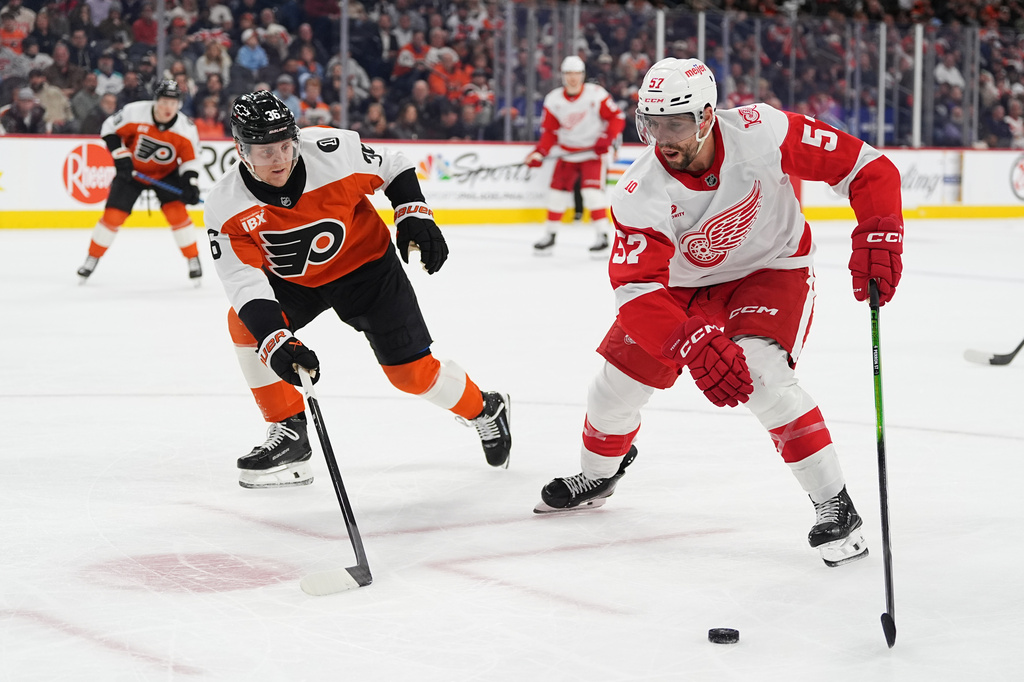 Detroit Red Wings' David Perron (57) tries to skate past Philadelphia Flyers' Emil Andrae, front left, during the first period of an NHL hockey game, Thursday, April 2, 2026, in Philadelphia. (AP Photo/Matt Rourke)