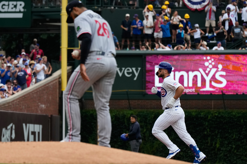 Chicago Cubs' Michael Busch, right, rounds the bases after hitting a solo home run as Minnesota Twins starting pitcher Taj Bradley looks down during the first inning of a baseball game in Chicago, Saturday, July 18, 2026. (AP Photo/Nam Y. Huh)