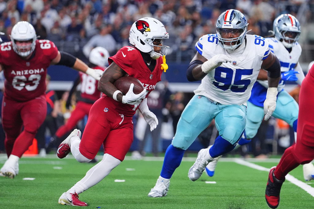 Arizona Cardinals wide receiver Greg Dortch (4) carries the ball as Dallas Cowboys' Kenny Clark (95) gives chase in the first half of an NFL football game Monday, Nov. 3, 2025, in Arlington, Texas. (AP Photo/Julio Cortez)