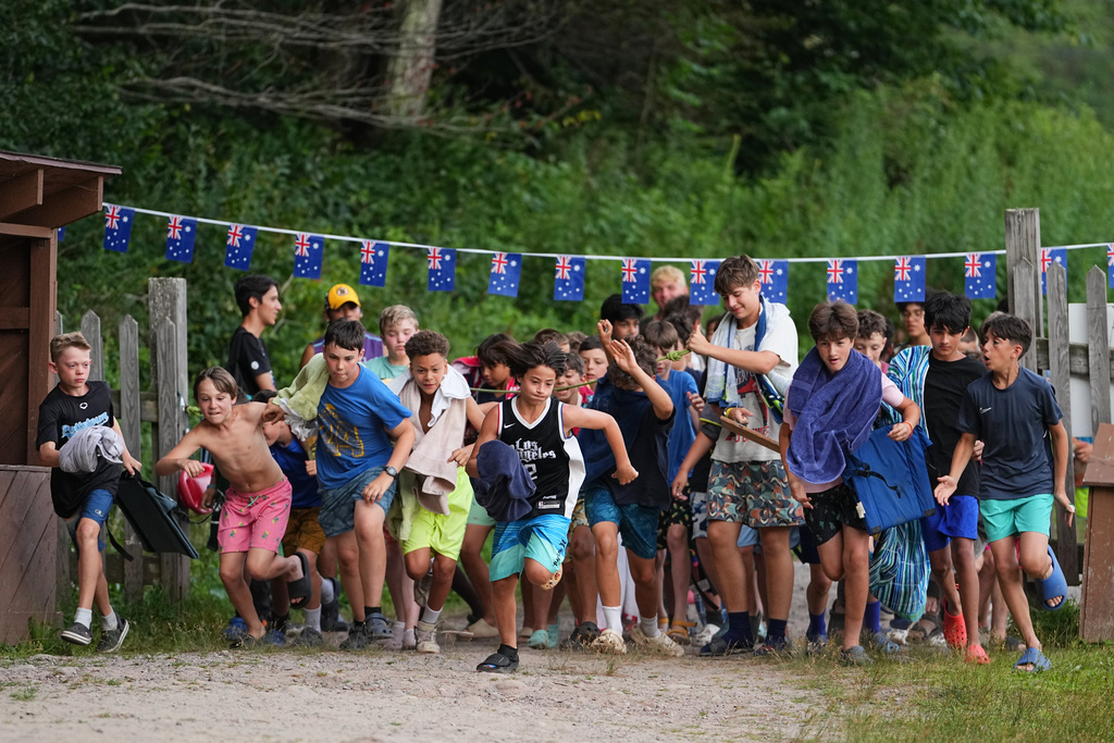 Campers run to the waterfront for an evening swim at the Frost Valley YMCA sleepaway camp in Claryville, N.Y., Wednesday, July 30, 2025. The camp partnered with Children's Hospital at Montefiore so kids with autoimmune diseases could attend for the first time. (AP Photo/Matt Rourke)