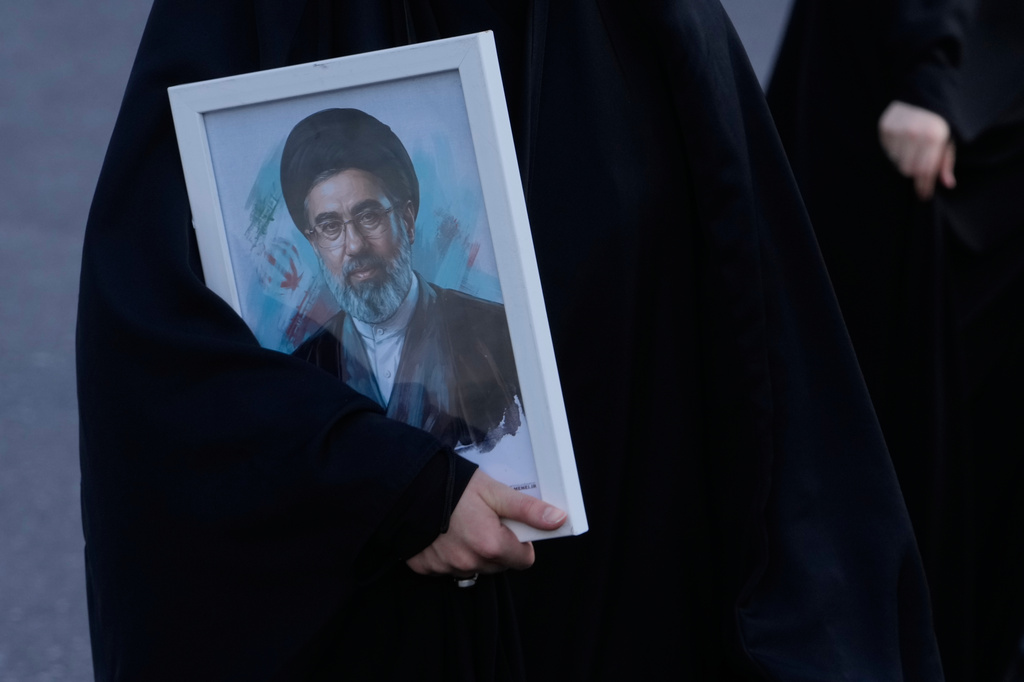 FILE - A woman holds a picture of the Iranian Supreme Leader Ayatollah Mojtaba Khamenei in a memorial for school children who were killed during a strike on a school in southern town of Minab on Feb. 28, in downtown Tehran, Iran, Tuesday, April 7, 2026. (AP Photo/Vahid Salemi, File)