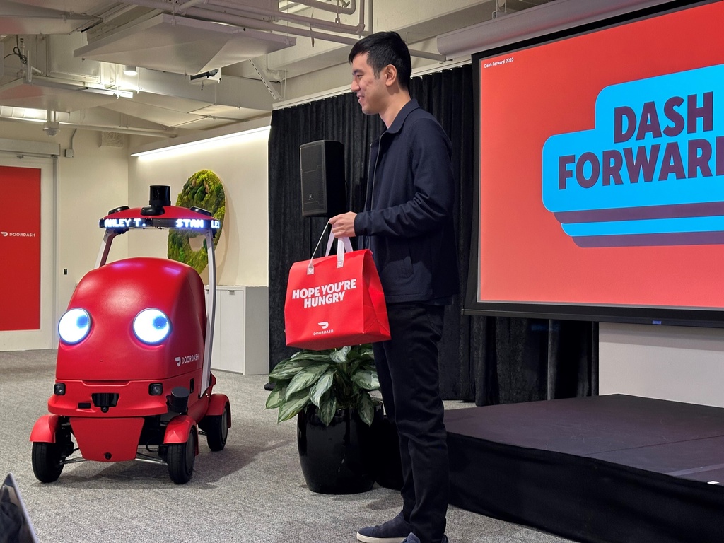 DoorDash co-founder Stanley Tang fetches a food delivery from a new delivery robot called Dot on Sept. 29, 2025, at DoorDash headquarters in San Francisco. (AP Photo/Michael Liedtke)