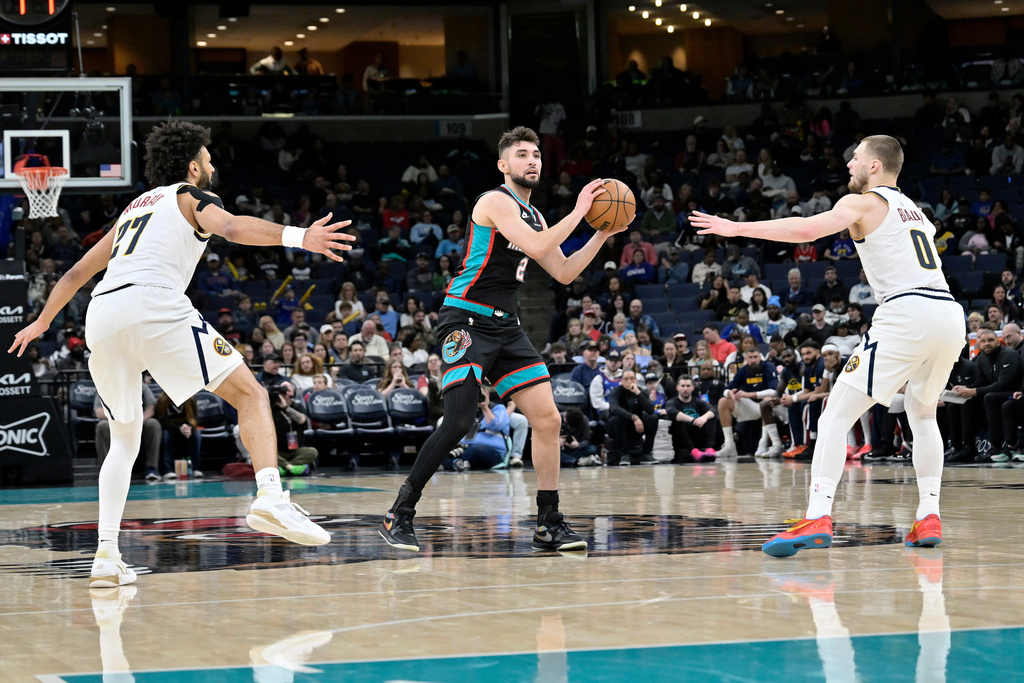 Memphis Grizzlies guard Ty Jerome (2) handles the ball between Denver Nuggets guards Jamal Murray (27) and Christian Braun (0) in the second half of an NBA basketball game Wednesday, March 18, 2026, in Memphis, Tenn. (AP Photo/Brandon Dill)