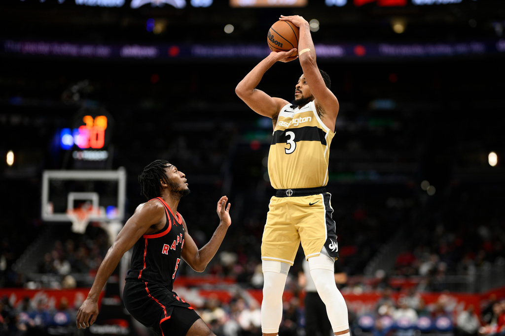 Washington Wizards guard CJ McCollum (3) goes up to shoot against Toronto Raptors guard Immanuel Quickley, left, during the second half of an NBA basketball game, Friday, Dec. 26, 2025, in Washington. (AP Photo/Nick Wass)