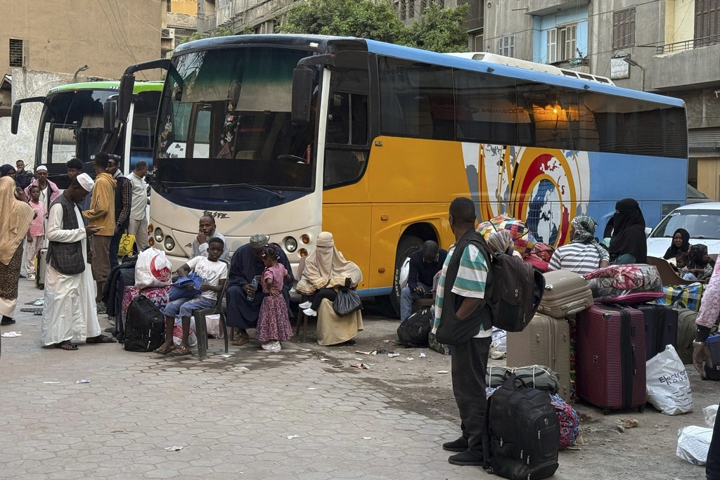 Sudanese people, who were driven from their homes and are now returning, crowd a bus station in Cairo, Egypt, Sunday, April 20, 2025. (AP Photo/Mohammed Salah)