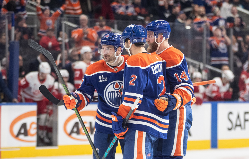 Edmonton Oilers' Zach Hyman (18), Evan Bouchard (2) and Mattias Ekholm (14) celebrate a goal against the Detroit Red Wings during second period NHL action, in Edmonton on Thursday, Dec. 11, 2025. (Jason Franson/The Canadian Press via AP)