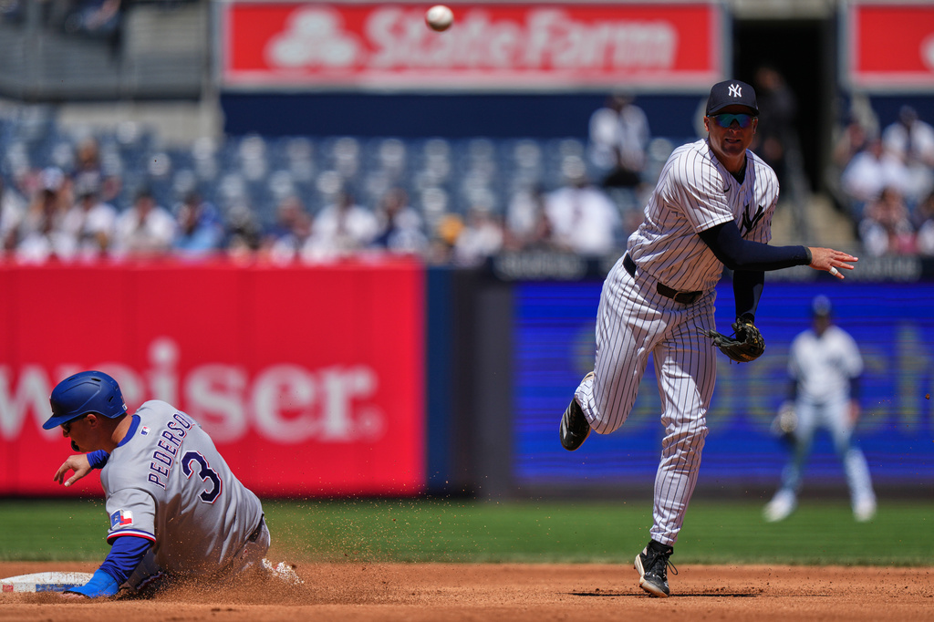 New York Yankees' Max Schuemann, right, throws to first base after forcing out Texas Rangers' Joc Pederson, left, during the third inning of a baseball game Thursday, May 7, 2026, in New York. (AP Photo/Frank Franklin II)