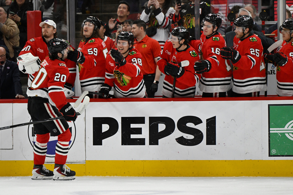 Chicago Blackhawks' Ryan Greene (20) celebrates with teammates at the bench after scoring during the first period of an NHL hockey game against the Buffalo Sabres in Chicago, Monday, April 13, 2026. (AP Photo/Paul Beaty)