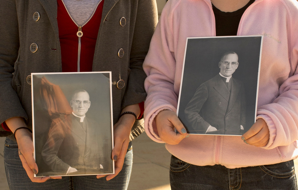 FILE - Boys Town students hold portraits of Boys Town founder Father Edward Flanagan outside St. Cecilia Cathedral in Omaha, Neb., Feb. 27, 2012. (AP Photo/Nati Harnik, File)