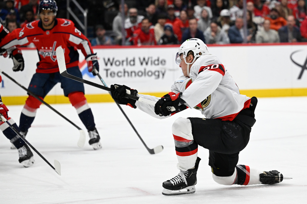 Ottawa Senators left wing Fabian Zetterlund, right, follows through on a shot during the second period of an NHL hockey game against the Washington Capitals, Wednesday, March 18, 2026, in Washington. (AP Photo/John McDonnell)