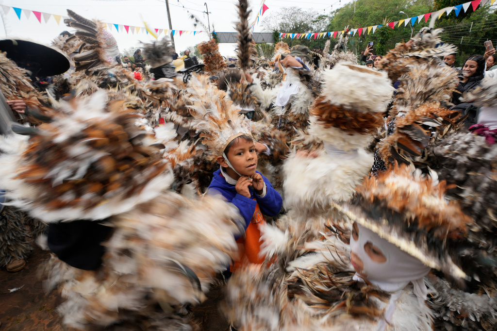 Parishioners wearing a birdlike costumes dance in the annual procession honoring 16th-century St. Francis Solano in Emboscada, Paraguay, Friday, July 24, 2026. (AP Photo/Jorge Saenz)
