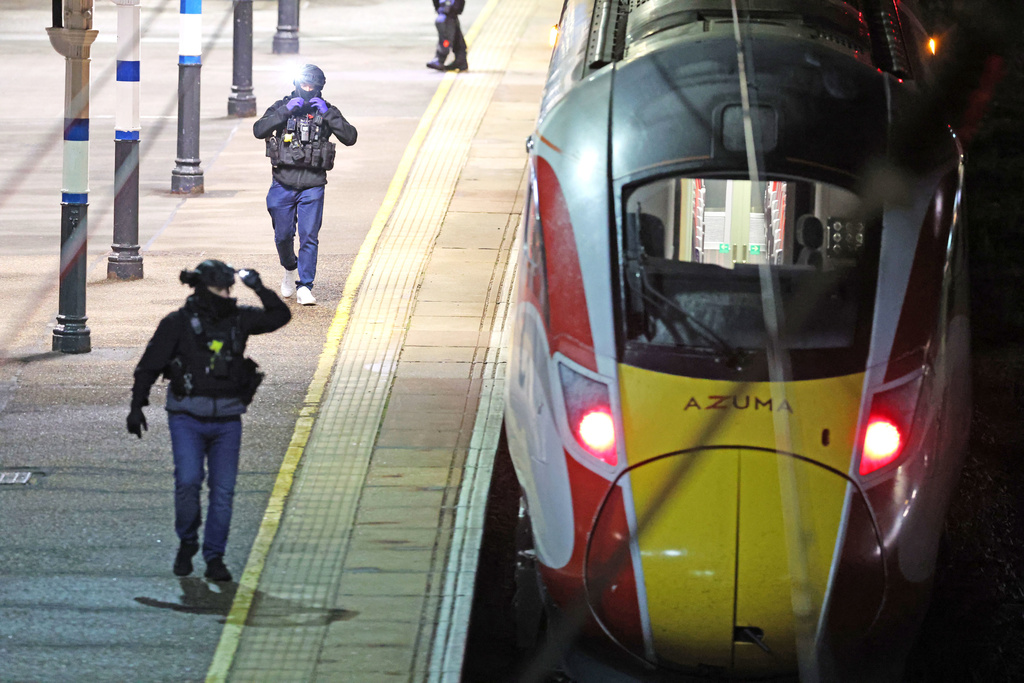 Police on the platform by the train at Huntingdon station after a mass stabbing on a London-bound train in eastern England, in Cambridgeshire, England, Saturday, Nov. 1, 2025. (Chris Radburn/PA via AP)