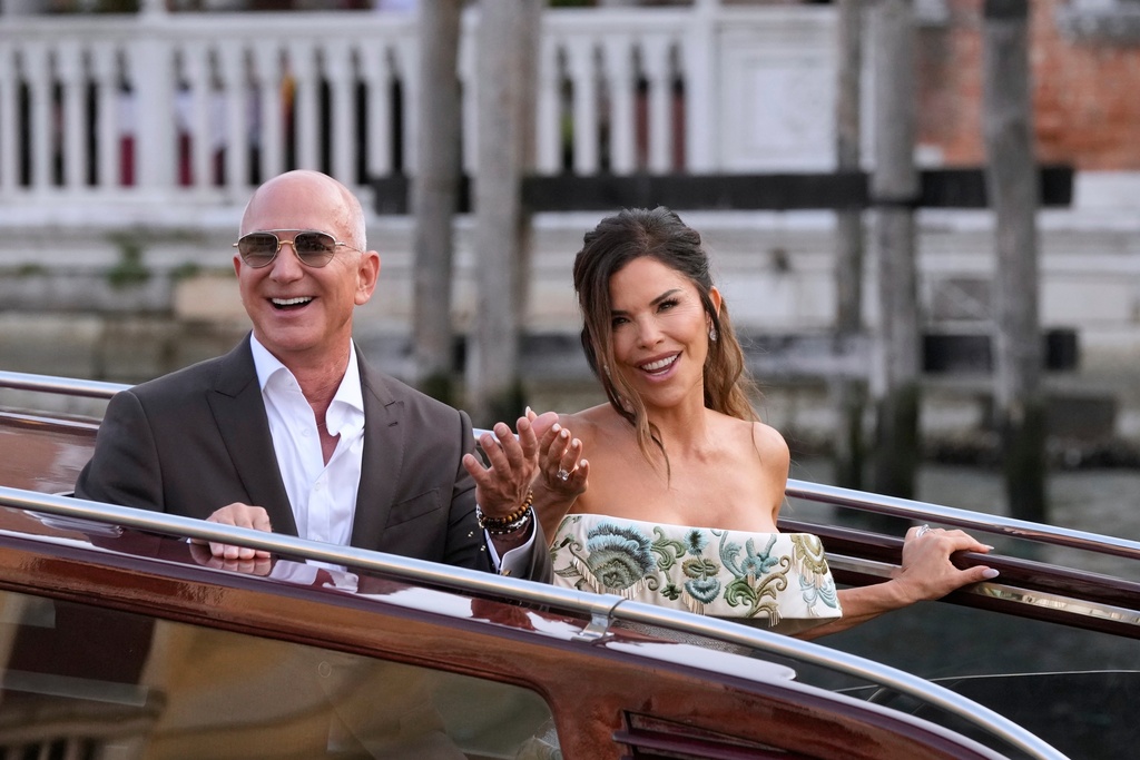 FILE - Jeff Bezos, left, and Lauren Sanchez leave a hotel for their pre wedding reception, in Venice, Italy, Thursday, June 26, 2025. (AP Photo/Luca Bruno, File)