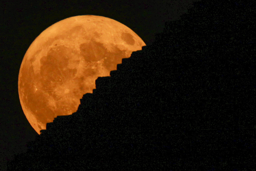 The supermoon rises behind the historical site of Giza Pyramids, near Cairo, Egypt, Monday, Aug. 19, 2024. (AP Photo/Amr Nabil)
