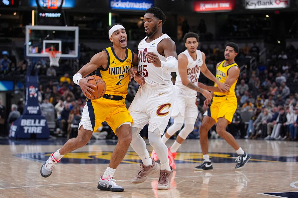 Indiana Pacers guard Andrew Nembhard (2) drives on Cleveland Cavaliers guard Donovan Mitchell (45) during the second half of an NBA basketball game in Indianapolis, Monday, Dec. 1, 2025. (AP Photo/Michael Conroy)