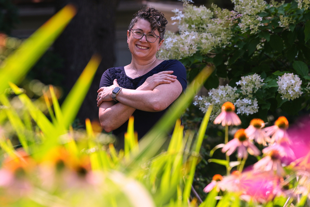 Ziva Mann, mother of a transgender child and member of a welcoming synagogue, poses in her garden, Wednesday, Aug. 13, 2025, in Newton, Mass. (AP Photo/Charles Krupa)