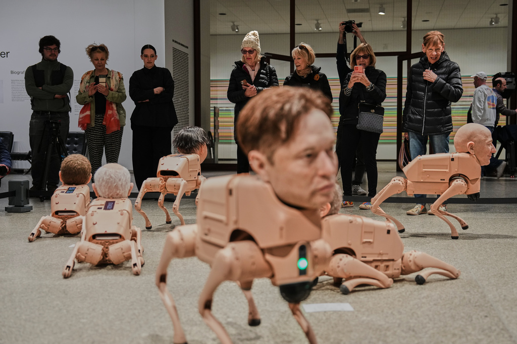 Robots in the likeness of Elon Musk, foreground, and Jeff Bezos, right, are displayed at the installation titled Regular Animals by artist Beeple, Mike Winkelmann, at the Neue Nationalgalerie museum in Berlin, Germany, Tuesday, April 28, 2026. (AP Photo/Markus Schreiber)