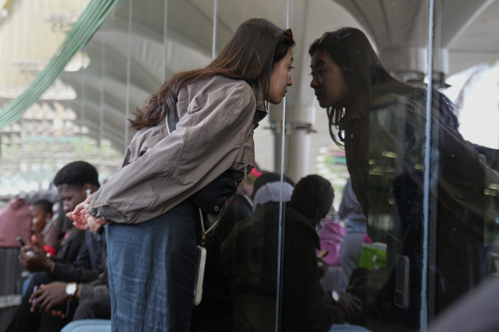 A passenger looks at herself in a mirror during a workers strike at Jomo Kenyatta International Airport in Nairobi, Kenya, Monday, Aug. 31, 2026. (AP Photo/Brian Inganga)