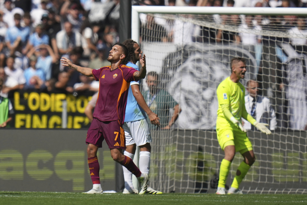 Roma's Lorenzo Pellegrini, left, celebrates after scoring his side's opening goal during an Italian Serie A soccer match between Lazio and Roma, at the Olimpic Stadium, in Rome, Italy, Sunday, Sept. 21, 2025. (AP Photo/Alessandra Tarantino)