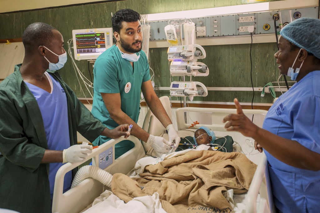 A doctor and staff members check on Anashe Mugoba as she recovers recovers from an open-heart surgery at Parirenyatwa Hospital, Harare, Zimbabwe, Thursday, July 17, 2025. (AP Photo/Aaron Ufumeli)