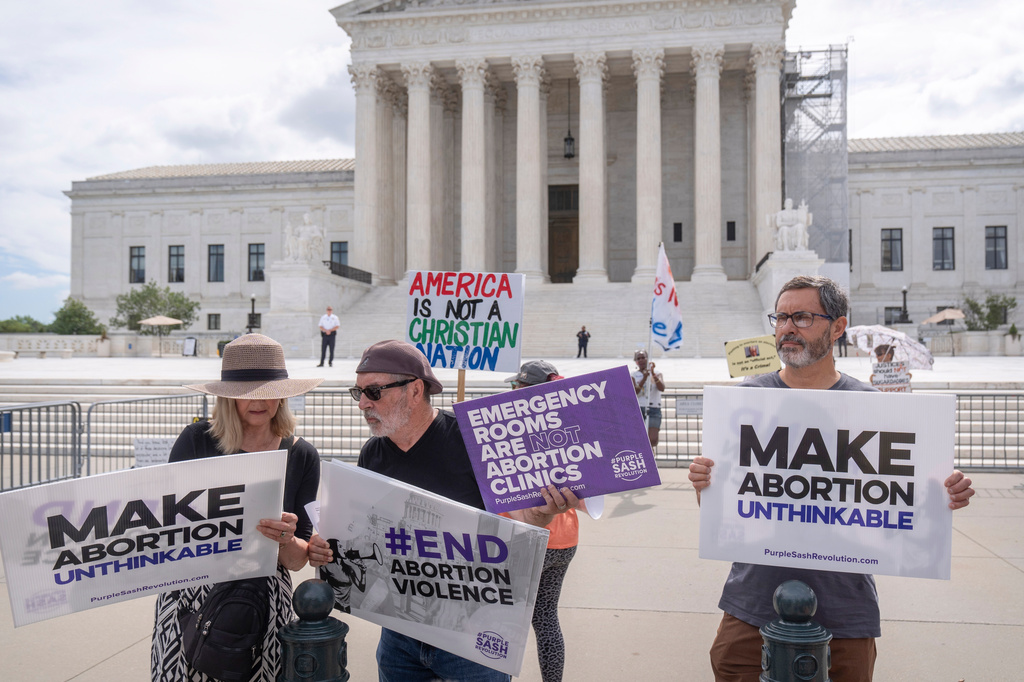 FILE - Katie Mahoney, left, and Rev. Patrick Mahoney, chief strategy officer for Stanton Healthcare, an Idaho-based pregnancy center that does not provide abortions, read the text of a Supreme Court decision outside the Supreme Court, June 27, 2024, in Washington. (AP Photo/Mark Schiefelbein, File)