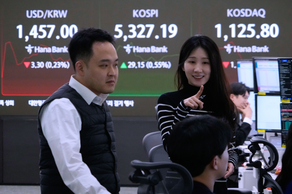 Currency traders work near a screen showing the Korea Composite Stock Price Index (KOSPI), top center, and the foreign exchange rate between U.S. dollar and South Korean won, top left, at the foreign exchange dealing room of the Hana Bank headquarters in Seoul, South Korea, Tuesday, Feb. 10, 2026. (AP Photo/Ahn Young-joon)