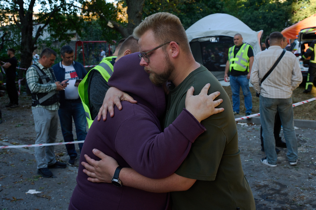 Relatives of a person killed during an overnight Russian attack comfort each other, in Kyiv, Ukraine, Thursday, Aug. 20, 2026 (AP Photo/Francisco Seco)