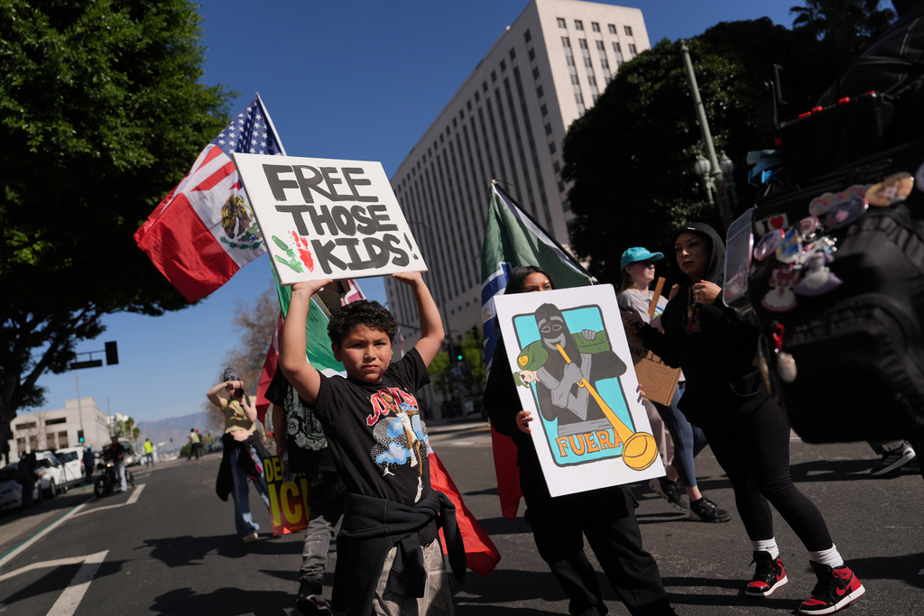 People gather near Los Angels City Hall, during a protest on Friday, Jan. 30, 2026. (AP Photo/Jae C. Hong)