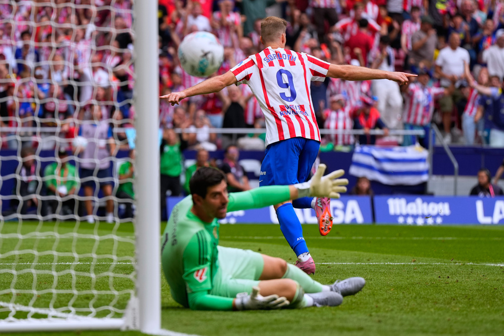 Atletico Madrid's Alexander Sorloth, top, celebrates after scoring his side's second goal past Real Madrid's goalkeeper Thibaut Courtois during the Spanish La Liga soccer match between Atletico Madrid and Real Madrid at Metropolitano stadium, in Madrid, Spain, Saturday, Sept. 27, 2025. (AP Photo/Manu Fernandez)