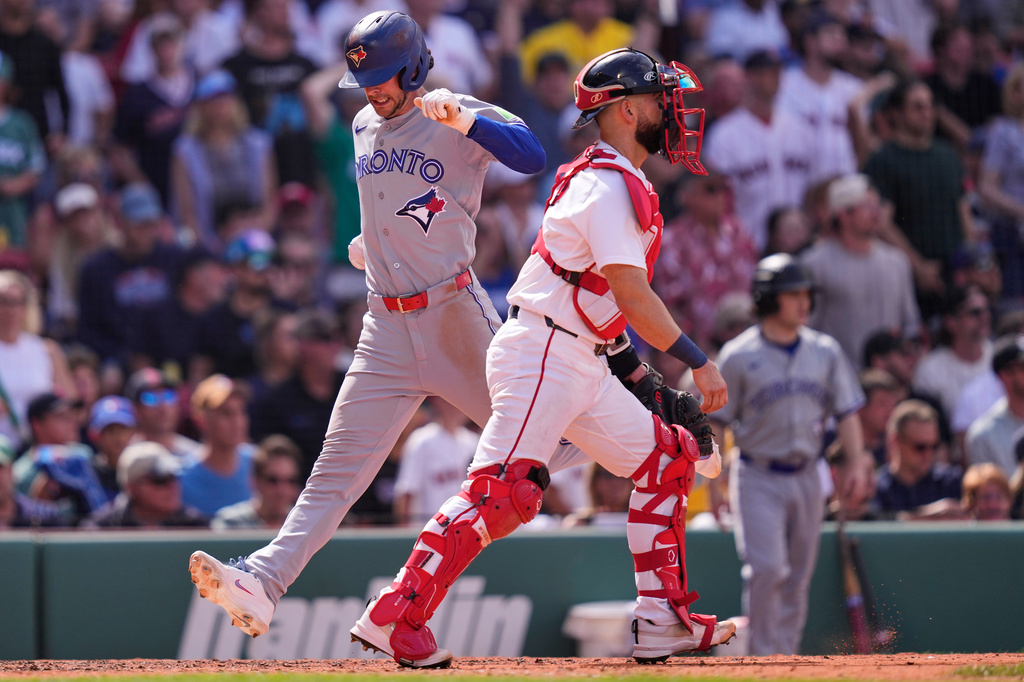 Toronto Blue Jays' Ernie Clement, left, beats the throw to Boston Red Sox catcher Connor Wong while scoring on a double by Brandon Valenzuela, which broke a tie, during the ninth inning of a baseball game against the Boston Red Sox, Thursday, June 18, 2026, in Boston. (AP Photo/Charles Krupa)
