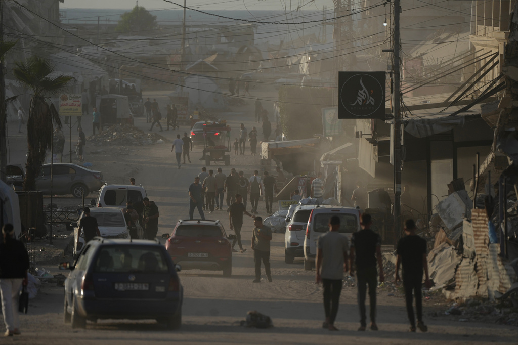 Palestinians walk along a street surrounded by war-damaged buildings in Gaza City, Saturday, Sept. 26, 2026. (AP Photo/Jehad Alshrafi)