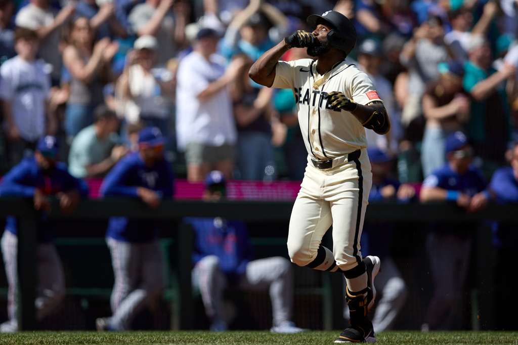 Seattle Mariners' Randy Arozarena reacts after hitting a two-run home run off Texas Rangers starting pitcher MacKenzie Gore during the fifth inning in a baseball game Sunday, April 19, 2026, in Seattle. (AP Photo/John Froschauer)