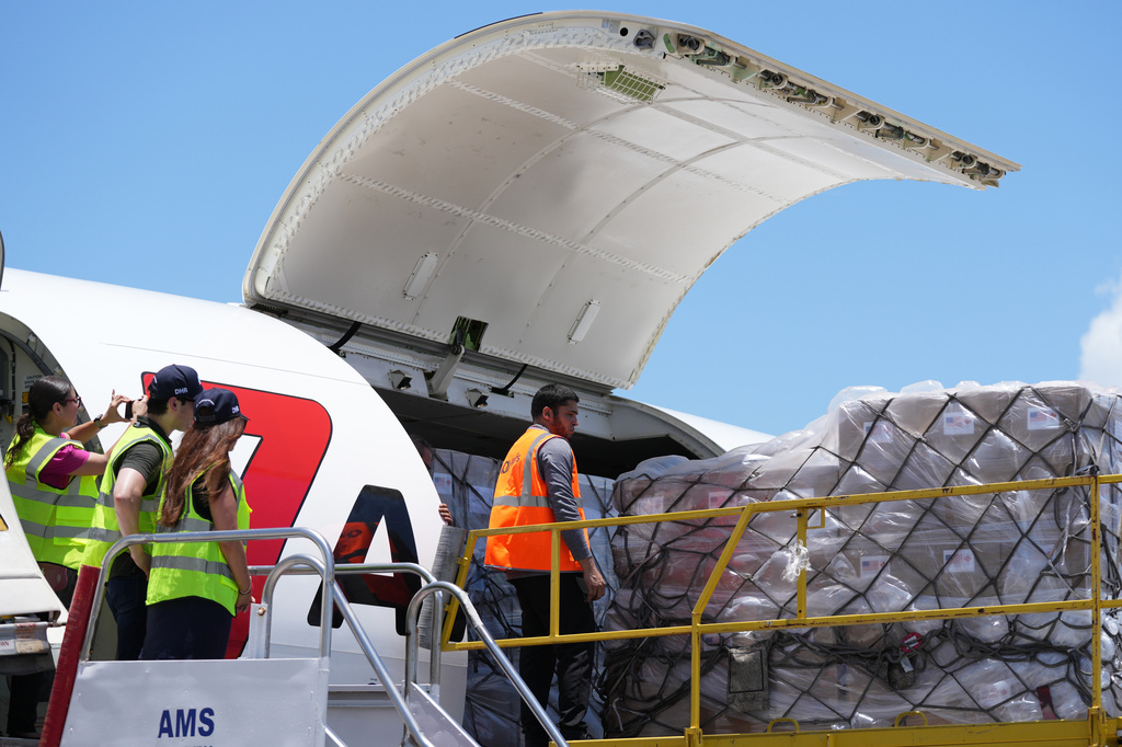 People load pallets containing food and hygiene kits for a humanitarian assistance flight to Cuba organized by the Trump administration as the U.S. continues to put pressure on the island's government, Tuesday, July 21, 2026, in Miami. (AP Photo/Lynne Sladky)