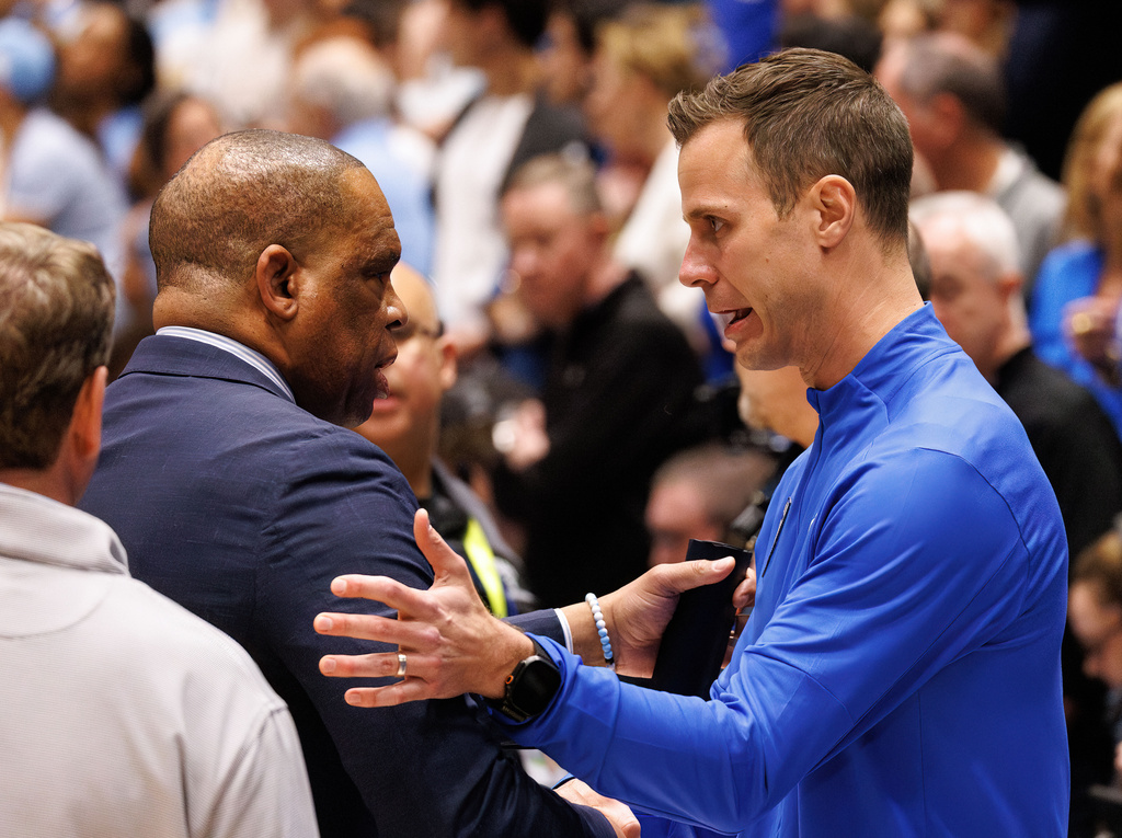 Duke head coach Jon Scheyer, right, and North Carolina head coach Hubert Davis, left, speak before an NCAA college basketball game in Durham, N.C., Saturday, March 7, 2026. (AP Photo/Ben McKeown)