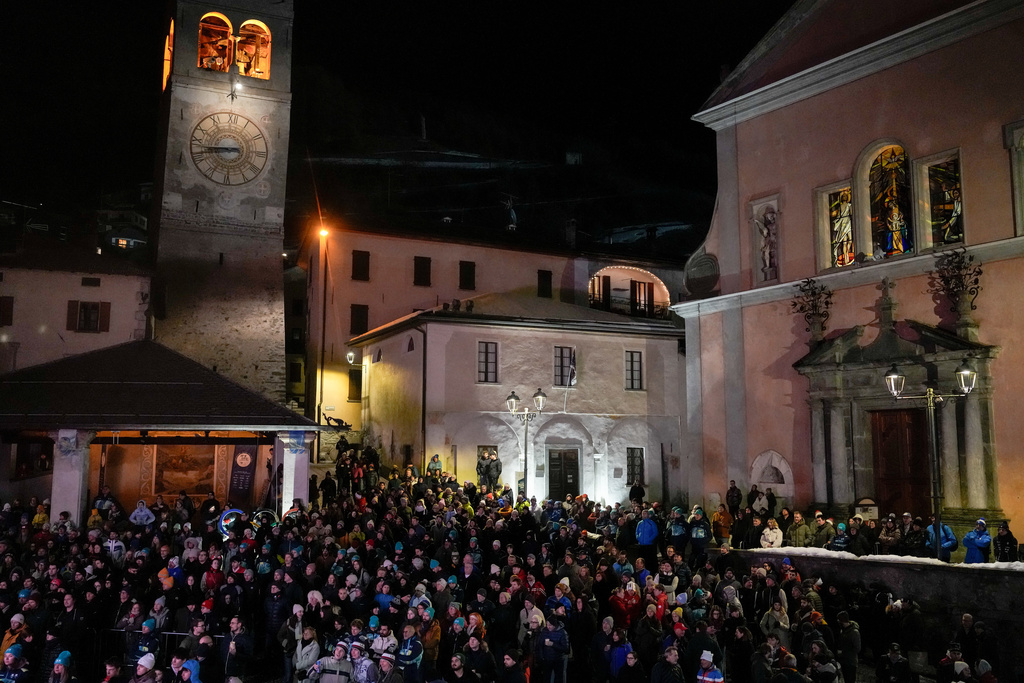 People watch the opening ceremony of the 2026 Winter Olympics at Piazza Cavour, Friday, Feb. 6, 2026, in Bormio, Italy. (AP Photo/Julia Demaree Nikhinson)