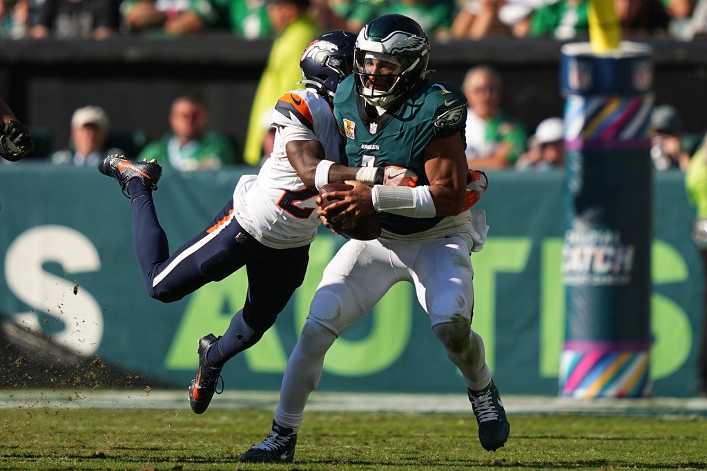 Denver Broncos cornerback Ja'Quan McMillian tackles Philadelphia Eagles quarterback Jalen Hurts during the second half of an NFL football game Sunday, Oct. 5, 2025, in Philadelphia. (AP Photo/Matt Rourke)