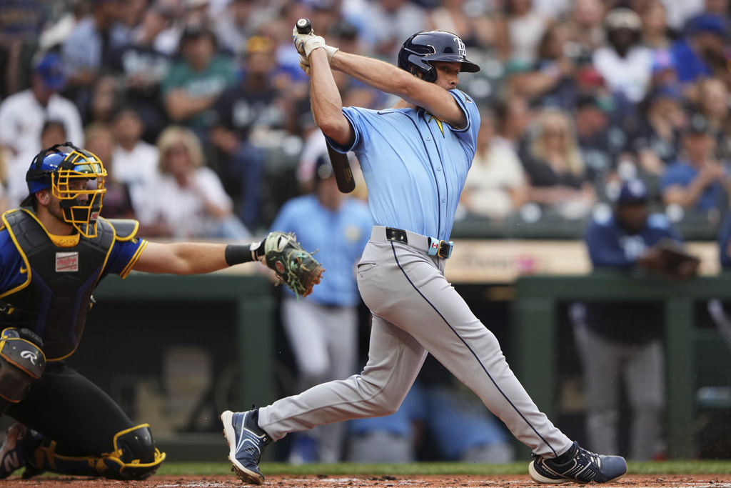 Tampa Bay Rays' Tristan Peters swings in his first major league at-bat as Seattle Mariners catcher Cal Raleigh looks on during the second inning of a baseball game Friday, Aug. 8, 2025, in Seattle. (AP Photo/Lindsey Wasson)