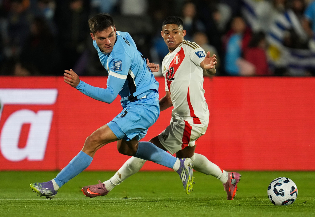 FILE - Uruguay's Manuel Ugarte, left, fights for the ball with Peru's Kevin Quevedo during a World Cup 2026 qualifying soccer match in Montevideo, Uruguay, Thursday, Sept. 4, 2025. (AP Photo/Matilde Campodonico, File)