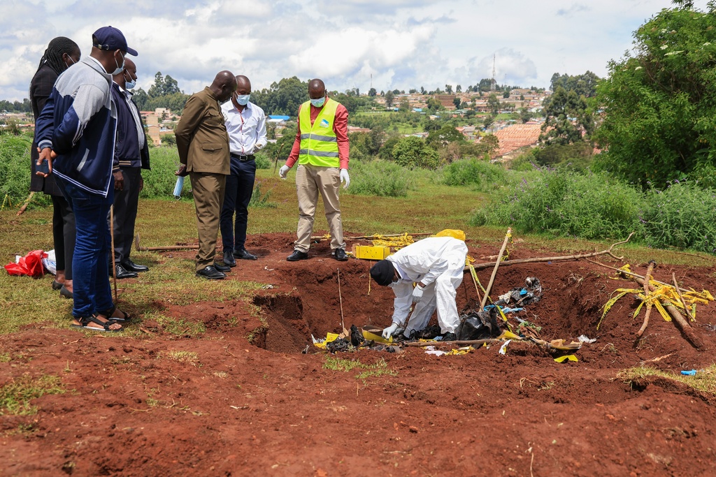 Directorate of Criminal Investigations (DCI) forensic staff inspect the scene of a mass grave where 33 bodies were exhumed at a cemetery in Kericho, Western Kenya Thursday, March 26, 2026. (AP Photo/Andrew Kasuku)