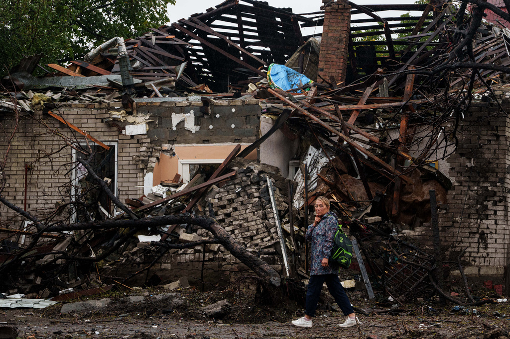 A woman walks in front of a house destroyed in a Russian strike on a residential neighbourhood in Kyiv, Ukraine, Thursday, Sept. 24, 2026. (AP Photo/Evgeniy Maloletka)