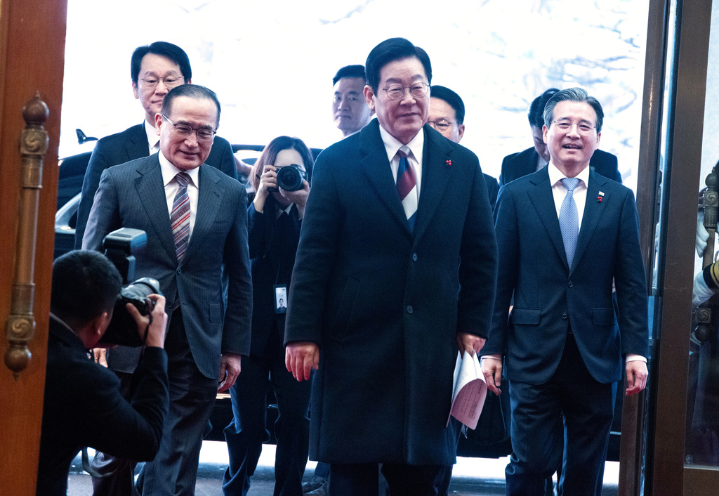 South Korean President Lee Jae Myung, center, arrives at the presidential office Cheong Wa Dae, or the Blue House in Seoul, Monday, Dec. 29, 2025 as Lee marked his first official day at Cheong Wa Dae on Monday after three years and seven months since the Yoon Seok-yeol government moved the presidential office to Yongsan in May 2022. (Jeoon Heon-Kyun/Pool Photo via AP)