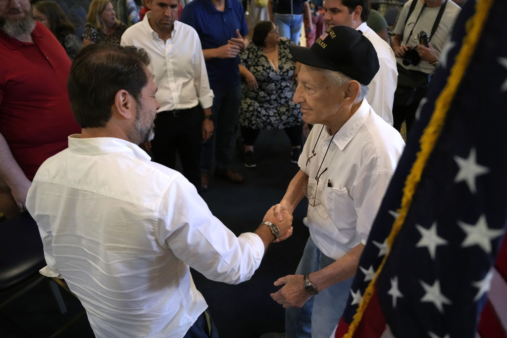 Sen. Ruben Gallego, D-Ariz., talks with Robert Francione, right, of Bettendorf, Iowa, during a town hall meeting, Saturday, Aug. 9, 2025, in Davenport, Iowa. (AP Photo/Charlie Neibergall)