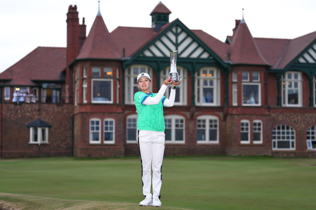 Shiho Kuwaki, of Japan, holds up the trophy after winning the Women's British Open golf championship in Lytham St Annes, England, Sunday, Aug. 2, 2026. (AP Photo/Jon Super)