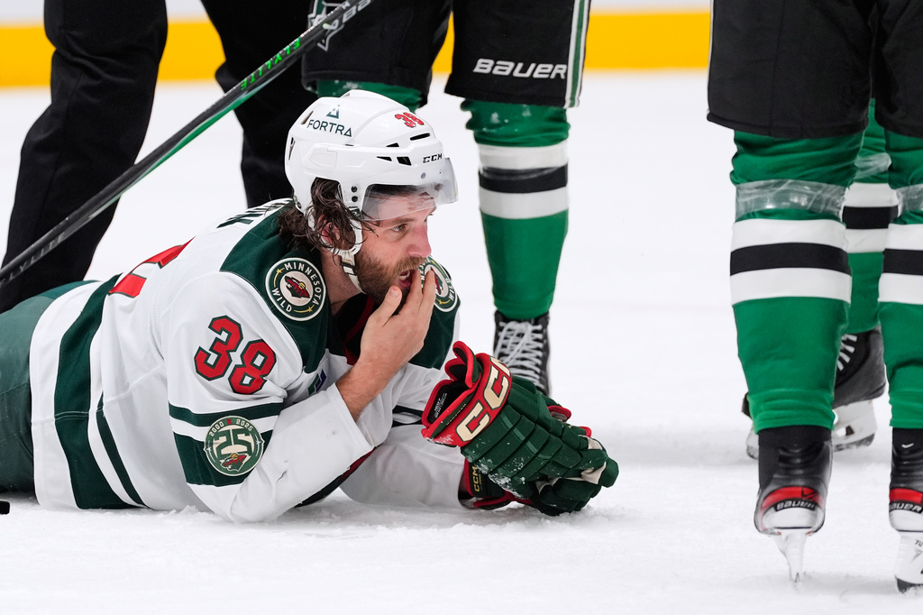 Minnesota Wild right wing Ryan Hartman checks his mouth after a stoppage in play against the Dallas Stars in the second period of an NHL hockey game Thursday, April 9, 2026, in Arlington, Texas. (AP Photo/Tony Gutierrez)
