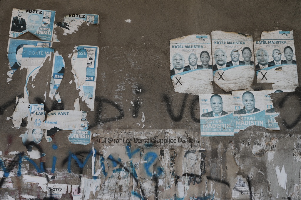 Old campaign posters from the 2016 presidential election cover a wall along a sidewalk in Port-au-Prince, Haiti, Monday, March 2, 2026. (AP Photo/Odelyn Joseph)